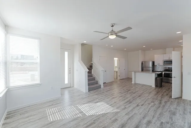 a view of a living room and kitchen with furniture wooden floor and windows