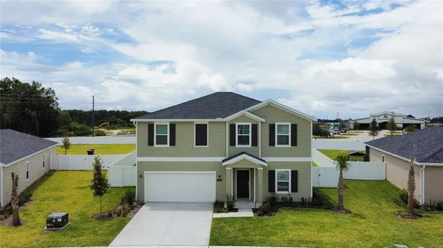 an aerial view of a house with swimming pool and a yard