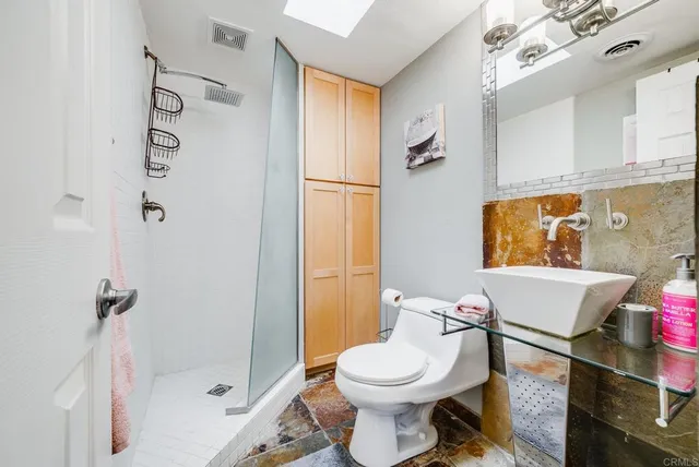 a spacious bedroom with a bed and a chandelier