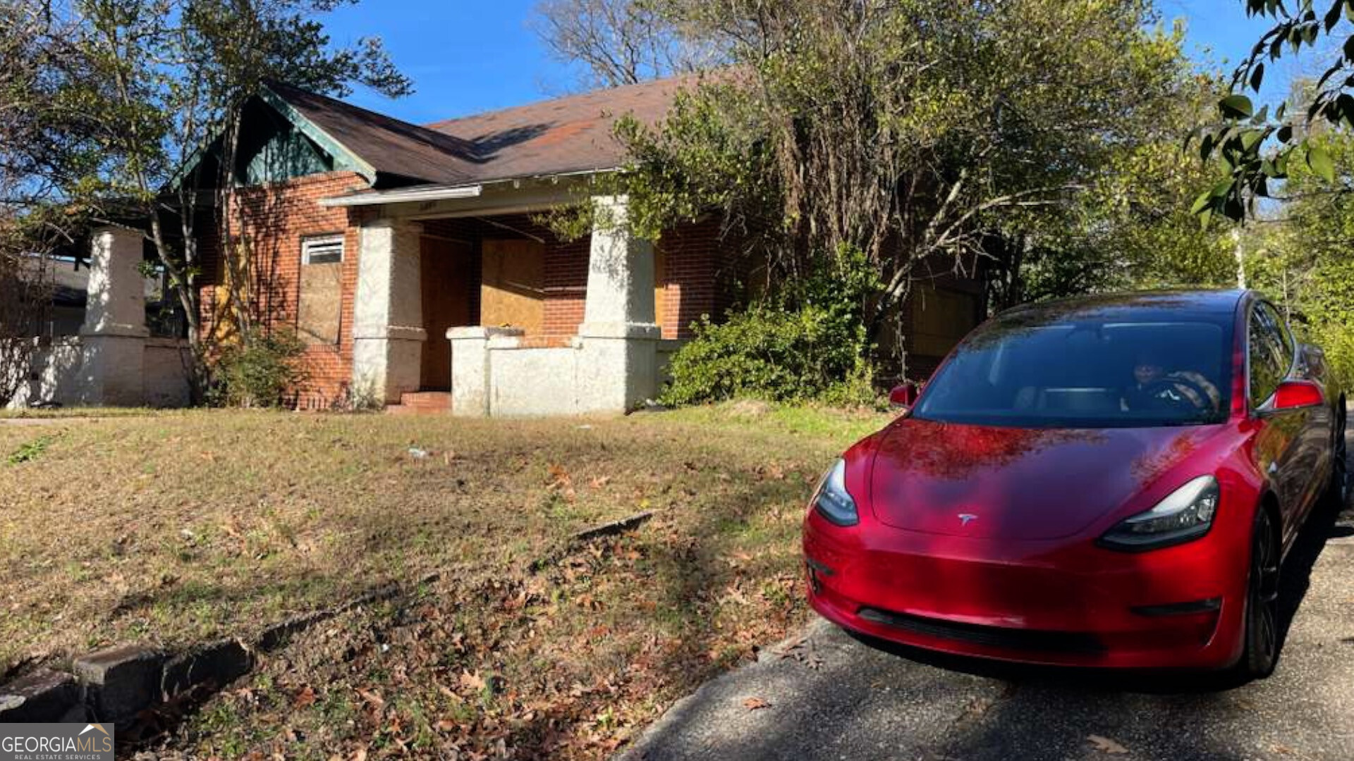 a view of a wooden house with a floor to ceiling window and tree