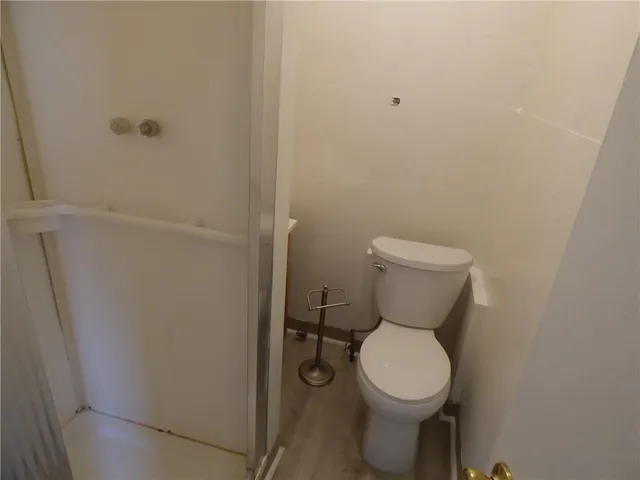 a white toilet sitting next to a shower