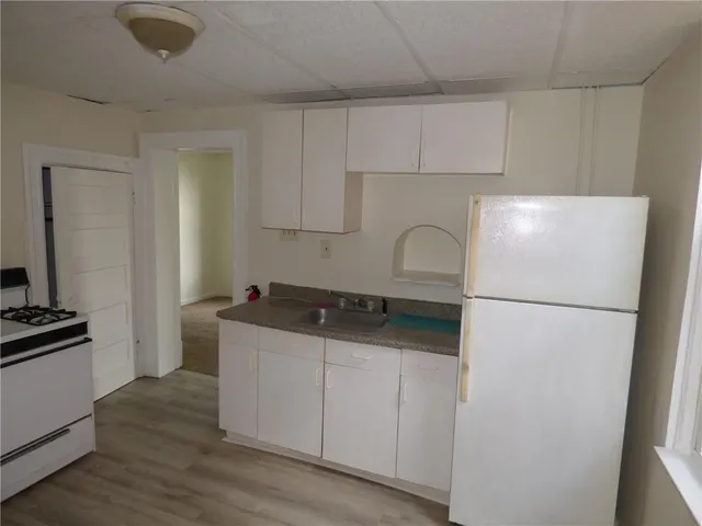 a kitchen with a refrigerator sink and cabinets