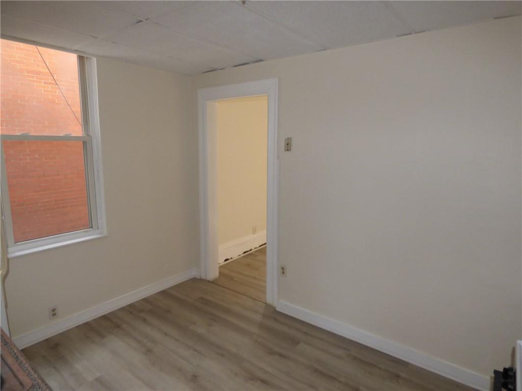 183 West Prospect Avenue, Unit 1B Pittsburgh, PA 15205 - Photo 7 of 17 an empty room with wooden floor and windows