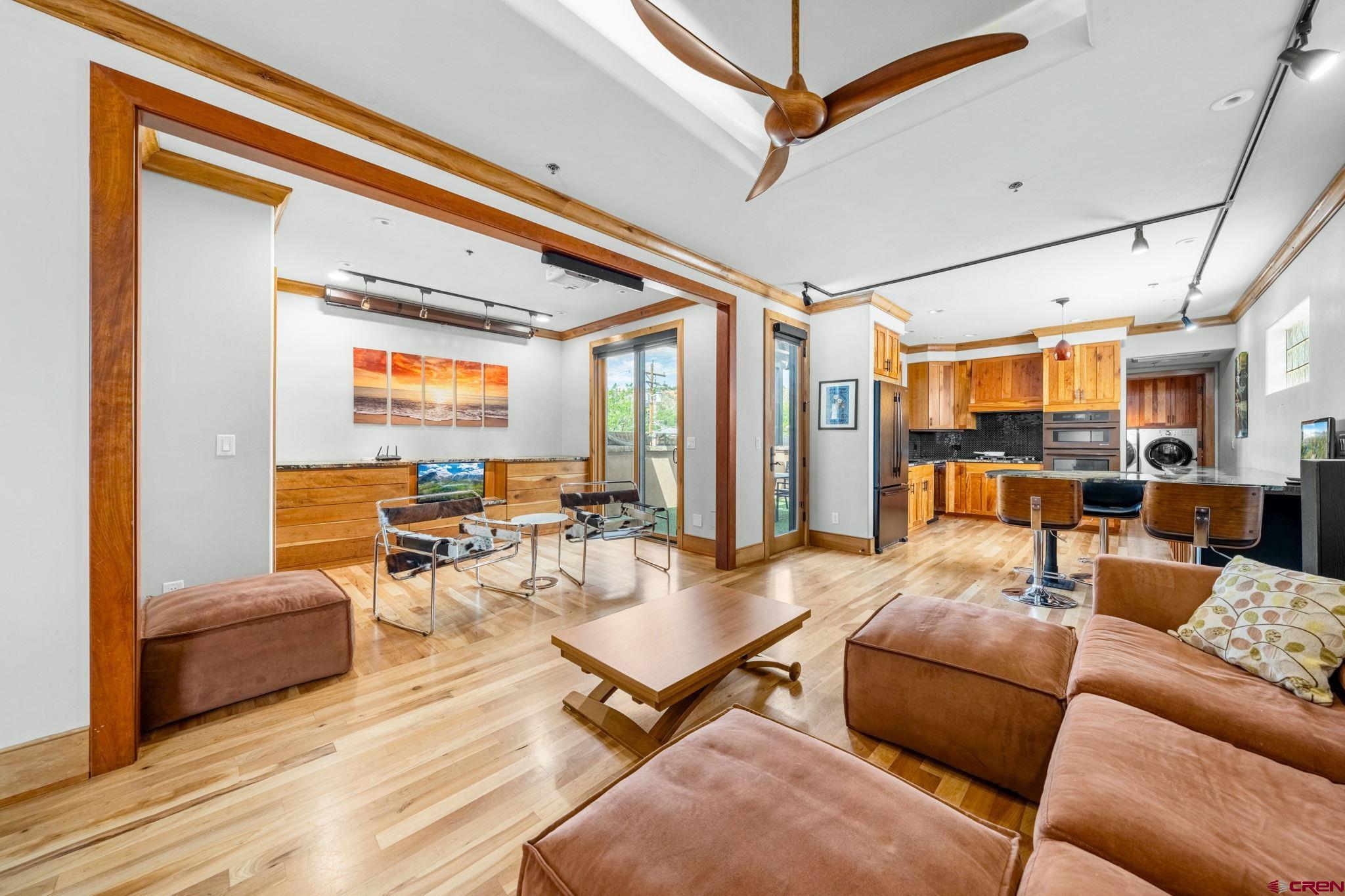a living room with furniture kitchen view and a large window