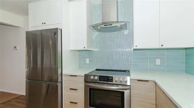 a kitchen with refrigerator and cabinets