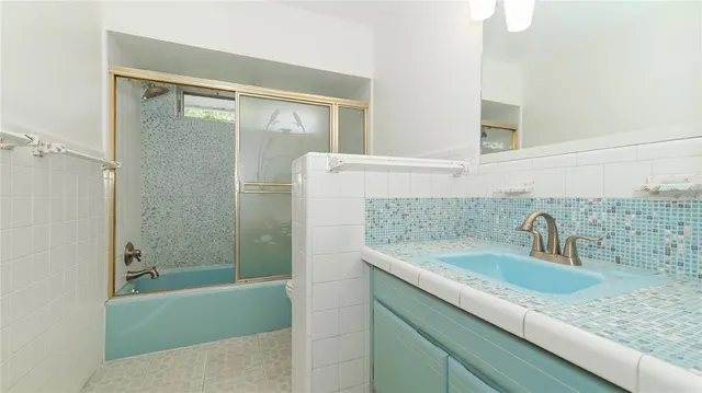 a bathroom with a granite countertop sink a mirror and shower