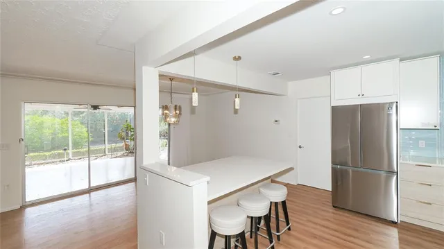 a kitchen with stainless steel appliances a refrigerator and wooden floor