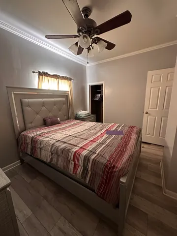 a bedroom with a bed and a ceiling fan