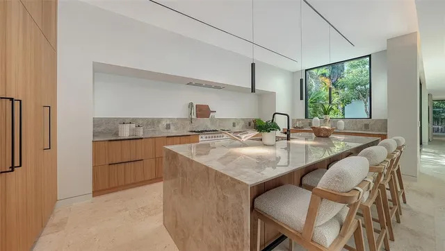 a kitchen with a stove and a view of living room