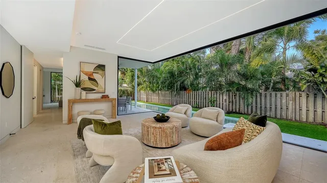 a living room with patio furniture and a garden