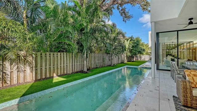 a view of a backyard with couches plants and large tree