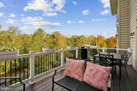 a living room with couches a chandelier and a dining table with wooden floor