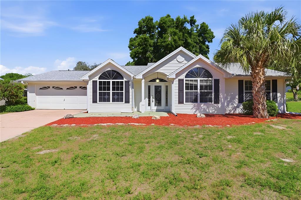 8105 Southwest 109th Street Ocala, FL 34481 - Photo 1 of 30 a front view of a house with a yard and potted plants