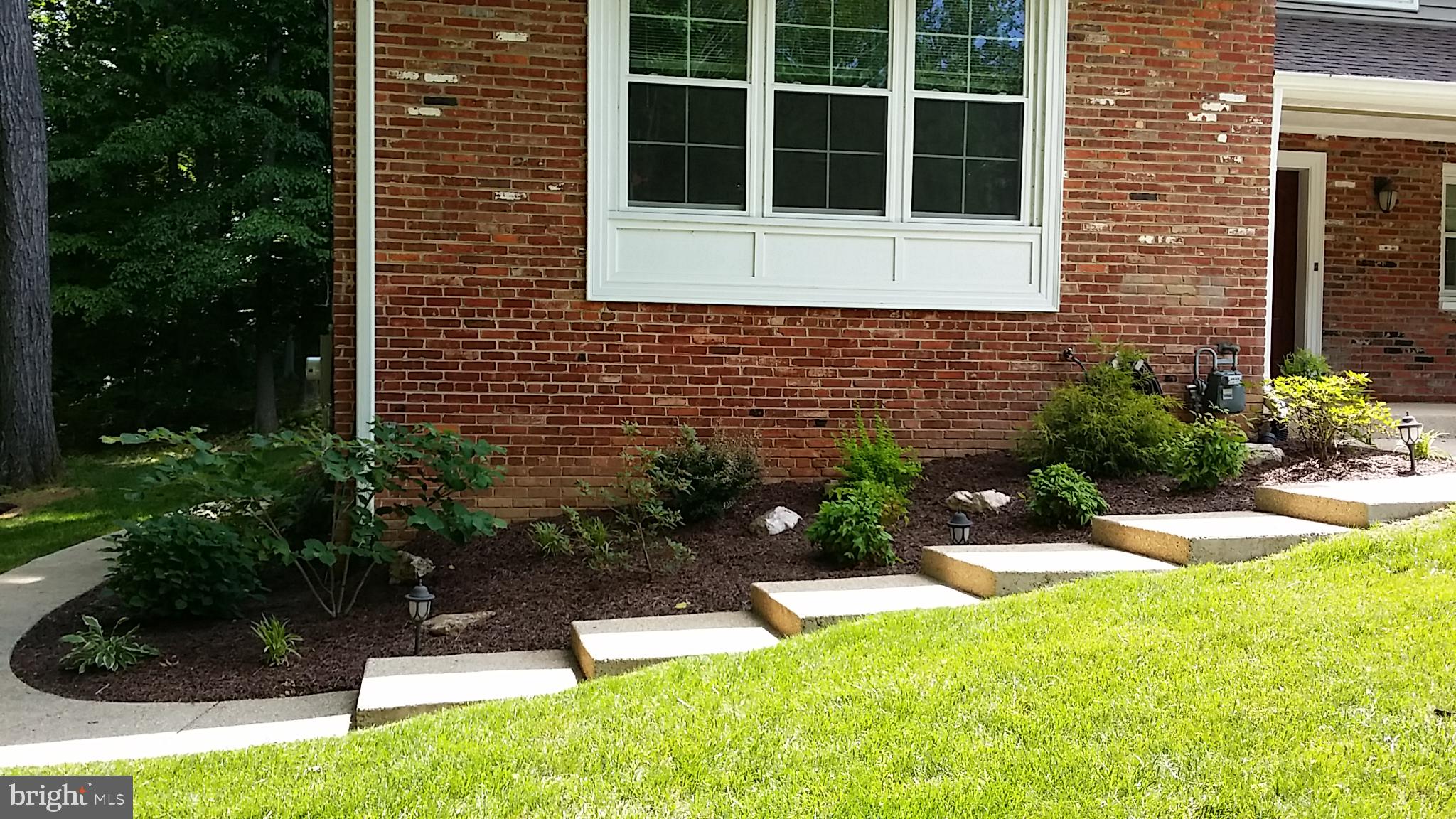 8543 Howell Road Bethesda, MD 20817 - Photo 2 of 24 a view of brick house with a yard and potted plants