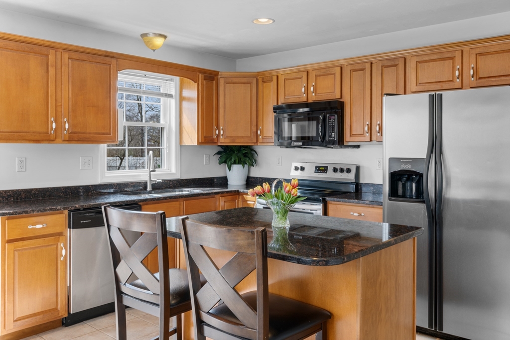 12 Pinckney Street, Unit A Taunton, MA 02780 - Photo 6 of 42 a kitchen with stainless steel appliances granite countertop a stove top oven a refrigerator a sink and a granite counter tops