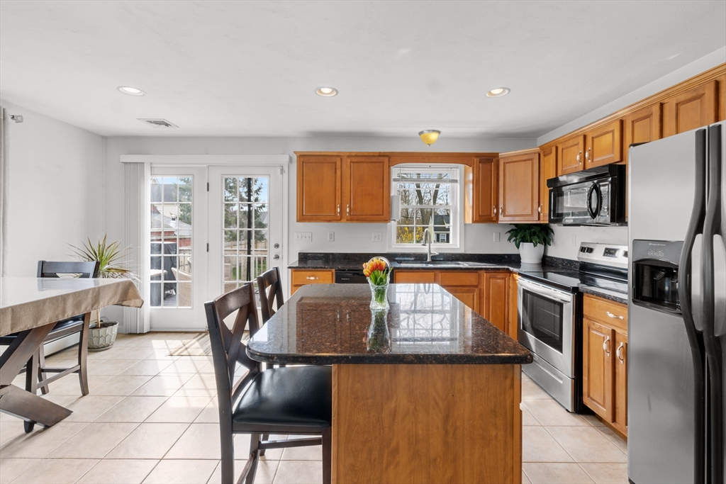 12 Pinckney Street, Unit A Taunton, MA 02780 - Photo 7 of 42 a kitchen with granite countertop a table chairs microwave and sink