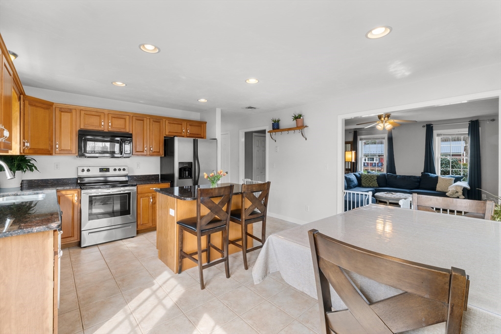 12 Pinckney Street, Unit A Taunton, MA 02780 - Photo 9 of 42 a kitchen with stainless steel appliances kitchen island granite countertop a sink and cabinets