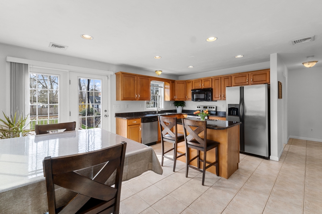 12 Pinckney Street, Unit A Taunton, MA 02780 - Photo 10 of 42 a kitchen with stainless steel appliances kitchen island granite countertop a refrigerator a stove a sink a dining table and chairs with the view of kitchen