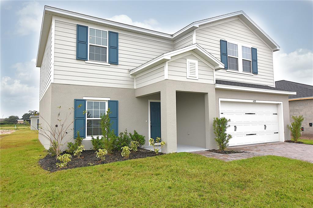 a front view of a house with a yard and garage