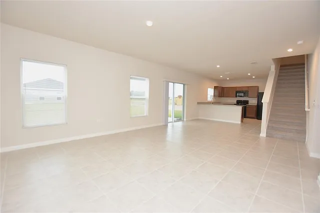 an empty room with a kitchen and windows