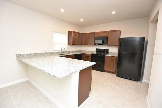 a kitchen with stainless steel appliances a refrigerator sink and microwave