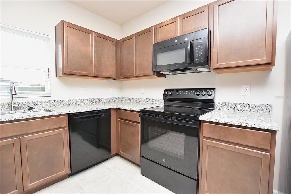 622 Manchester Path Dundee, FL 33838 - Photo 6 of 46 a kitchen with granite countertop cabinets stainless steel appliances and wooden floor