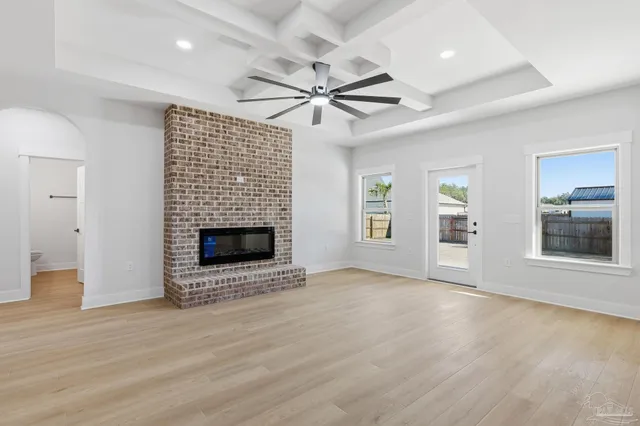 an empty room with windows and fireplace