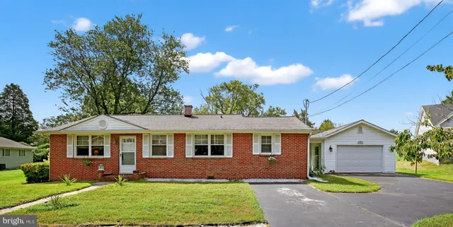 a front view of a house with a garden and yard