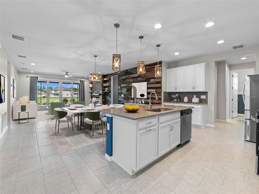 1010 Better Days Place Valrico, FL 33594 - Photo 14 of 55 a kitchen with stainless steel appliances kitchen island granite countertop a table and chairs