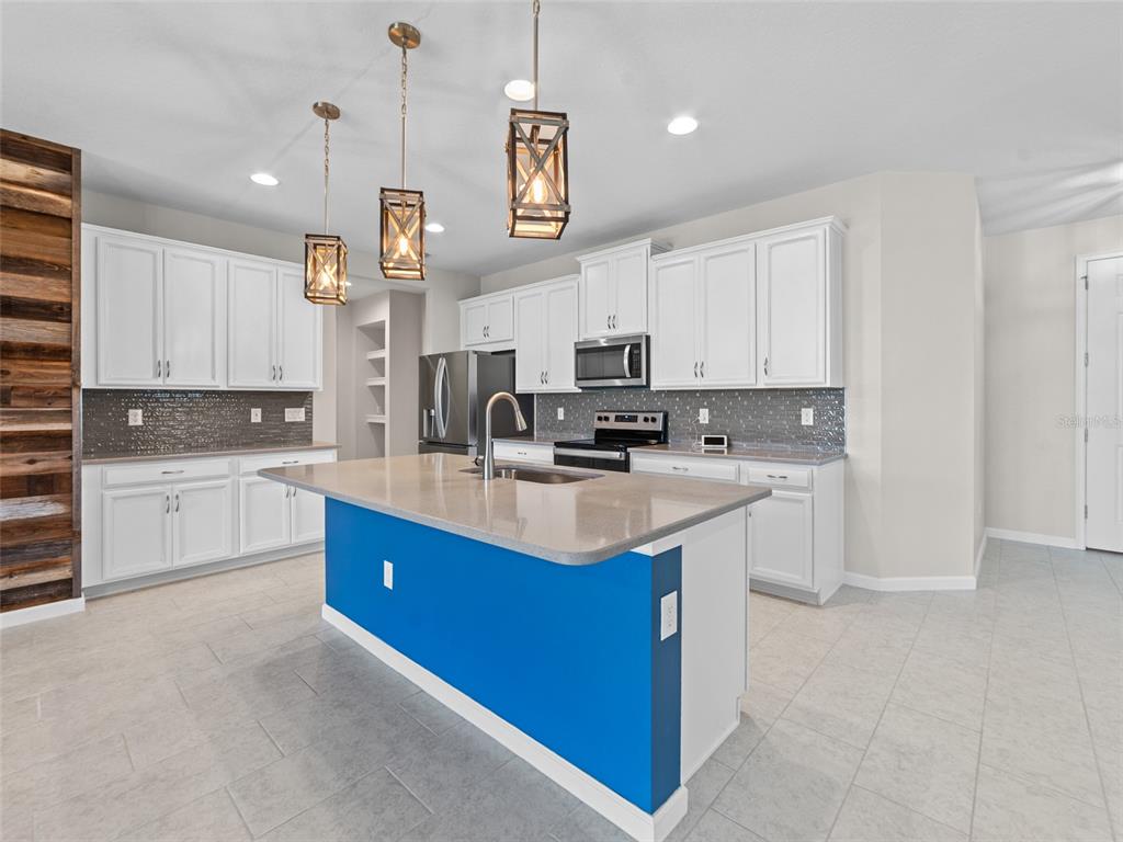 1010 Better Days Place Valrico, FL 33594 - Photo 16 of 55 a kitchen with kitchen island granite countertop a sink a counter top space and stainless steel appliances
