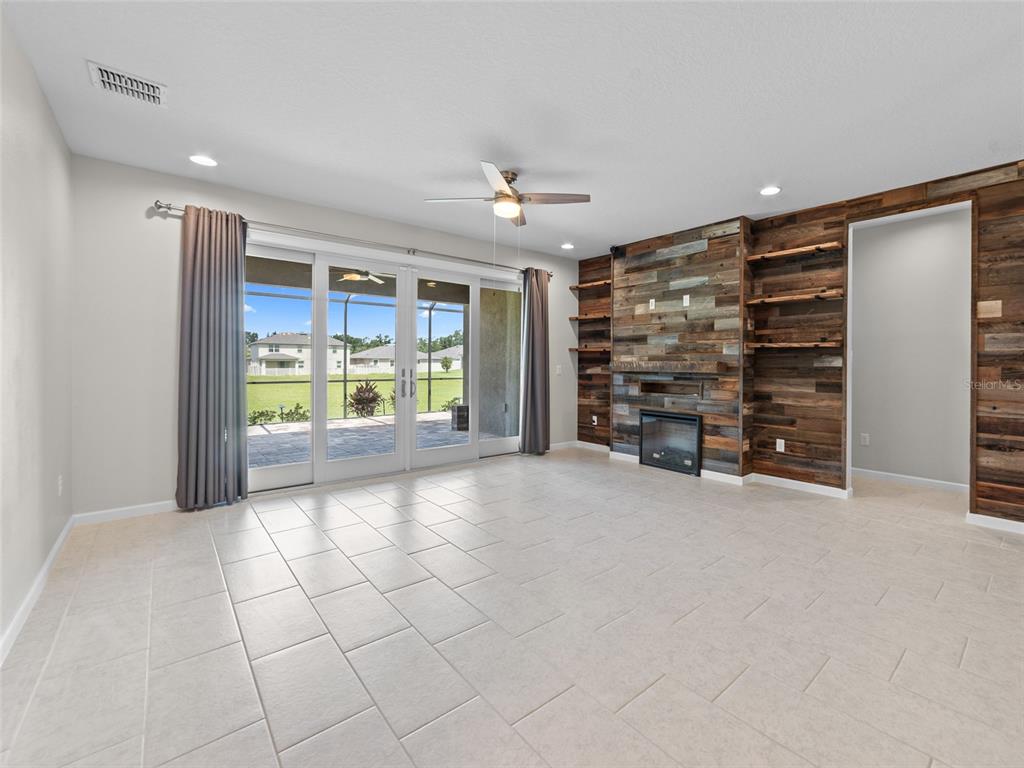 1010 Better Days Place Valrico, FL 33594 - Photo 23 of 55 a view of an empty room with a fireplace and a chandelier