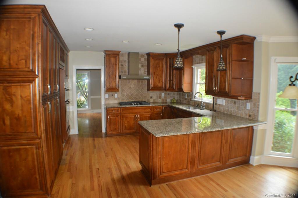 16336 Ranger Trail Huntersville, NC 28078 - Photo 5 of 12 a kitchen with stainless steel appliances granite countertop a sink a refrigerator a stove and a wooden floors