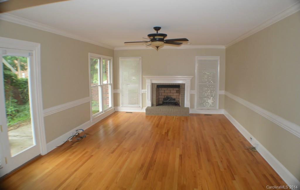 16336 Ranger Trail Huntersville, NC 28078 - Photo 7 of 12 an empty room with wooden floor fireplace and windows