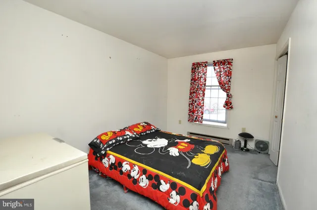 a bedroom with a bed and a dresser in it