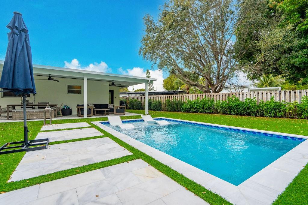 a view of a backyard with swimming pool and deck