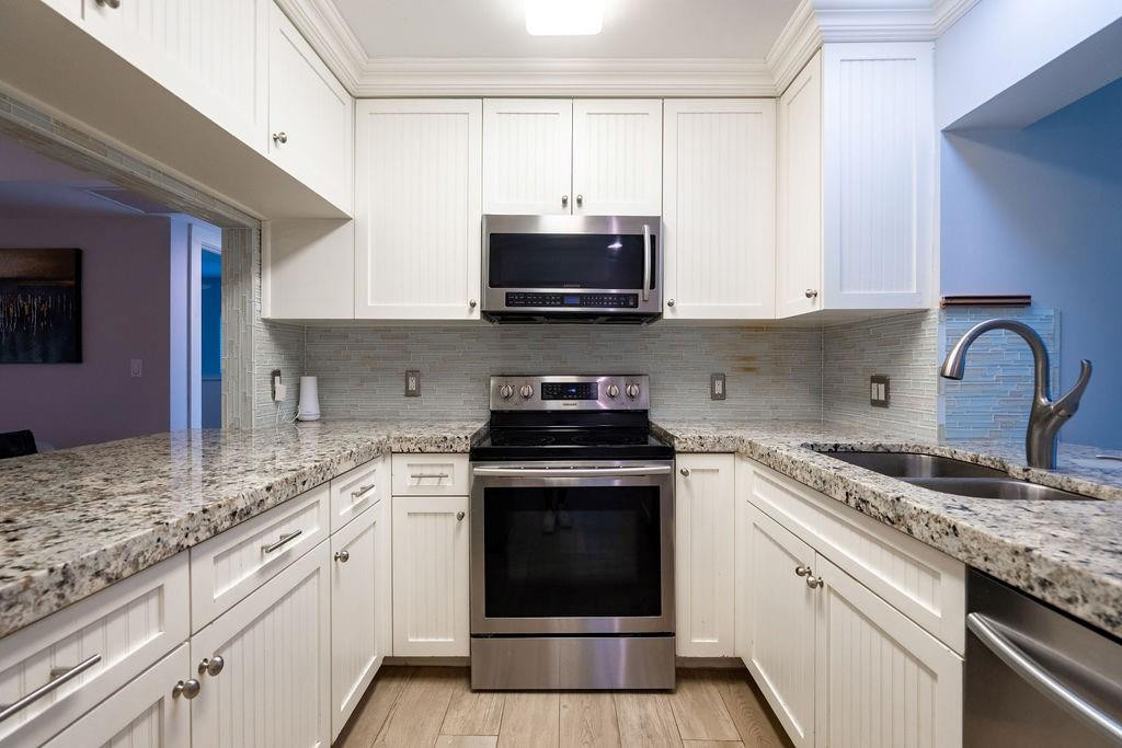 463 Newcastle Street Boca Raton, FL 33487 - Photo 11 of 32 a kitchen with granite countertop a stove top oven a sink and dishwasher