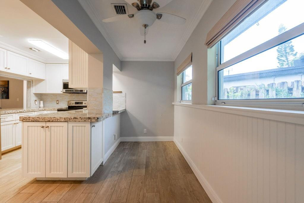463 Newcastle Street Boca Raton, FL 33487 - Photo 19 of 32 a large kitchen with granite countertop a large window a sink and stainless steel appliances