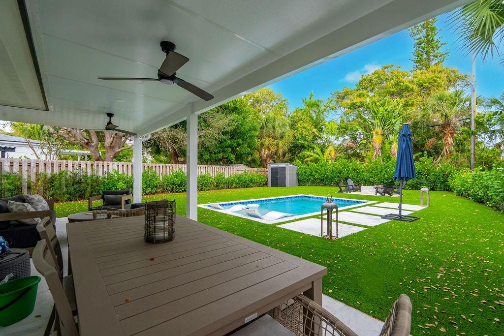 463 Newcastle Street Boca Raton, FL 33487 - Photo 26 of 32 a view of a patio with table and chairs potted plants with wooden fence