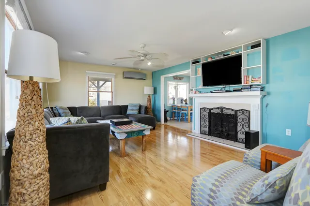 a living room with furniture a flat screen tv and a fireplace