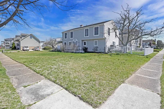 a view of a house with a yard and sitting area