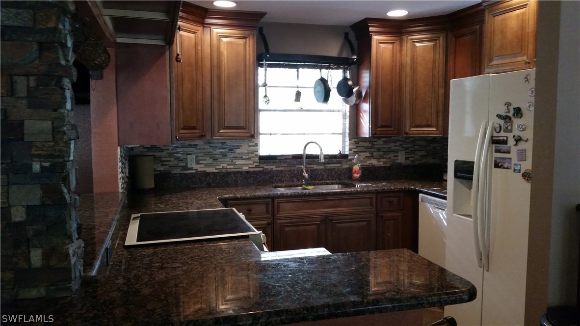 10831 Ruden Road North Fort Myers, FL 33917 - Photo 7 of 23 a kitchen with stainless steel appliances granite countertop a sink stove and refrigerator