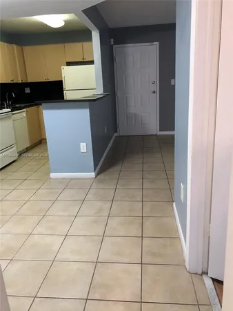 a kitchen with a white stove top oven and a refrigerator
