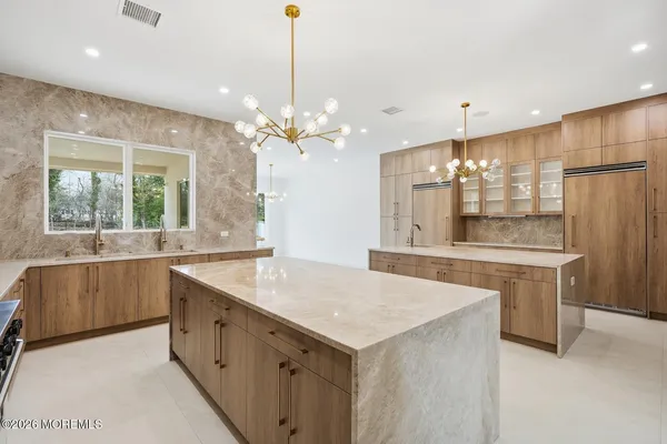 a large kitchen with kitchen island a large island in it