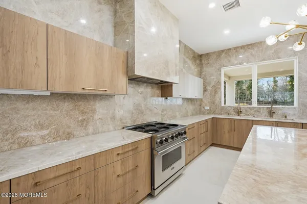 a kitchen with stainless steel appliances granite countertop a stove a sink and a granite counter tops