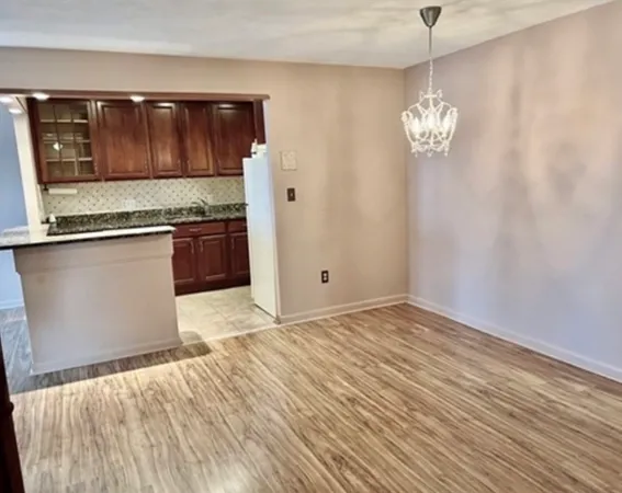 a view of granite countertop cabinets and wooden floor