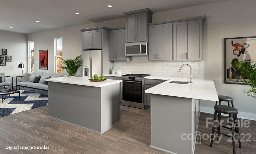 a kitchen with kitchen island stainless steel appliances a sink counter space and a sink
