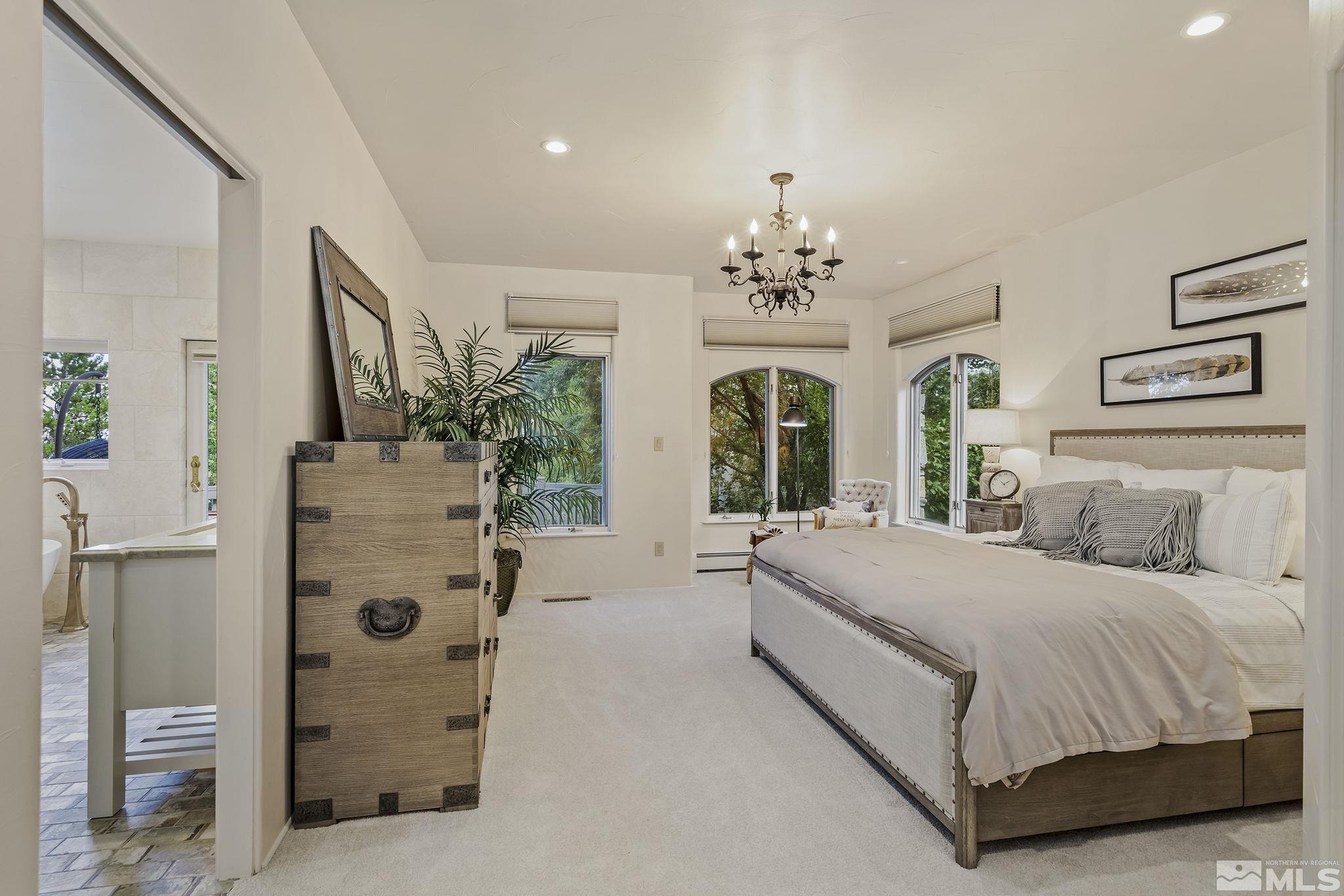 15 Promontory Pointe Reno, NV 89519 - Photo 16 of 40 a bedroom with a large bed and a chandelier