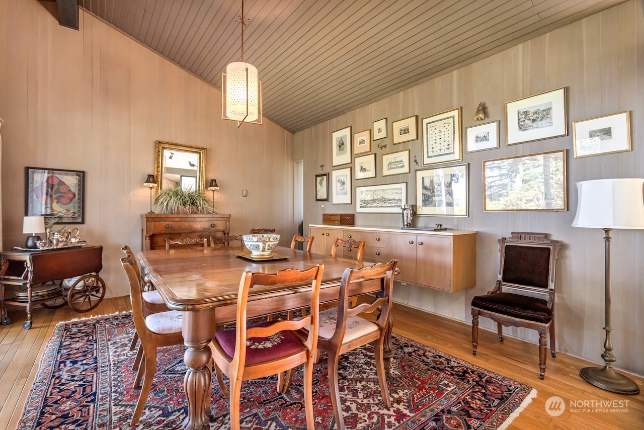 234 Middlefield Road Bellingham, WA 98225 - Photo 11 of 36 a dining room with wooden floor a chandelier a wooden table and chairs
