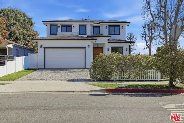 a front view of a house with a garden and garage