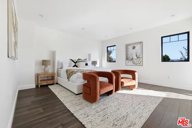 a bedroom with a bed and a painting on the wall